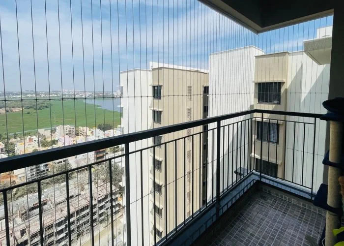Invisible grills on a corner apartment balcony overlooking a lake and green fields