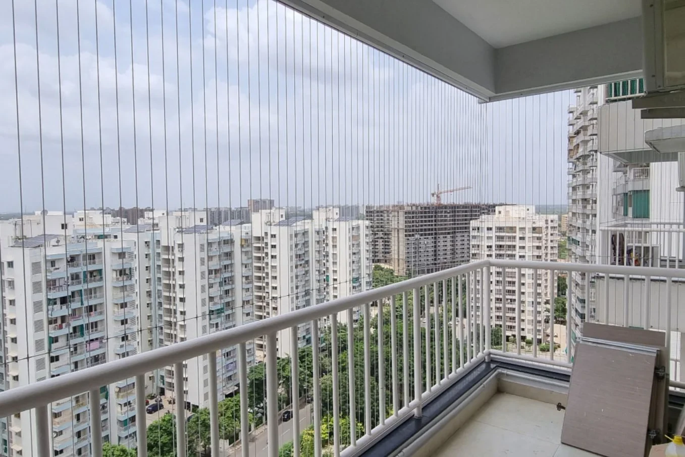 High-rise apartment balcony with invisible grills in front of a city skyline
