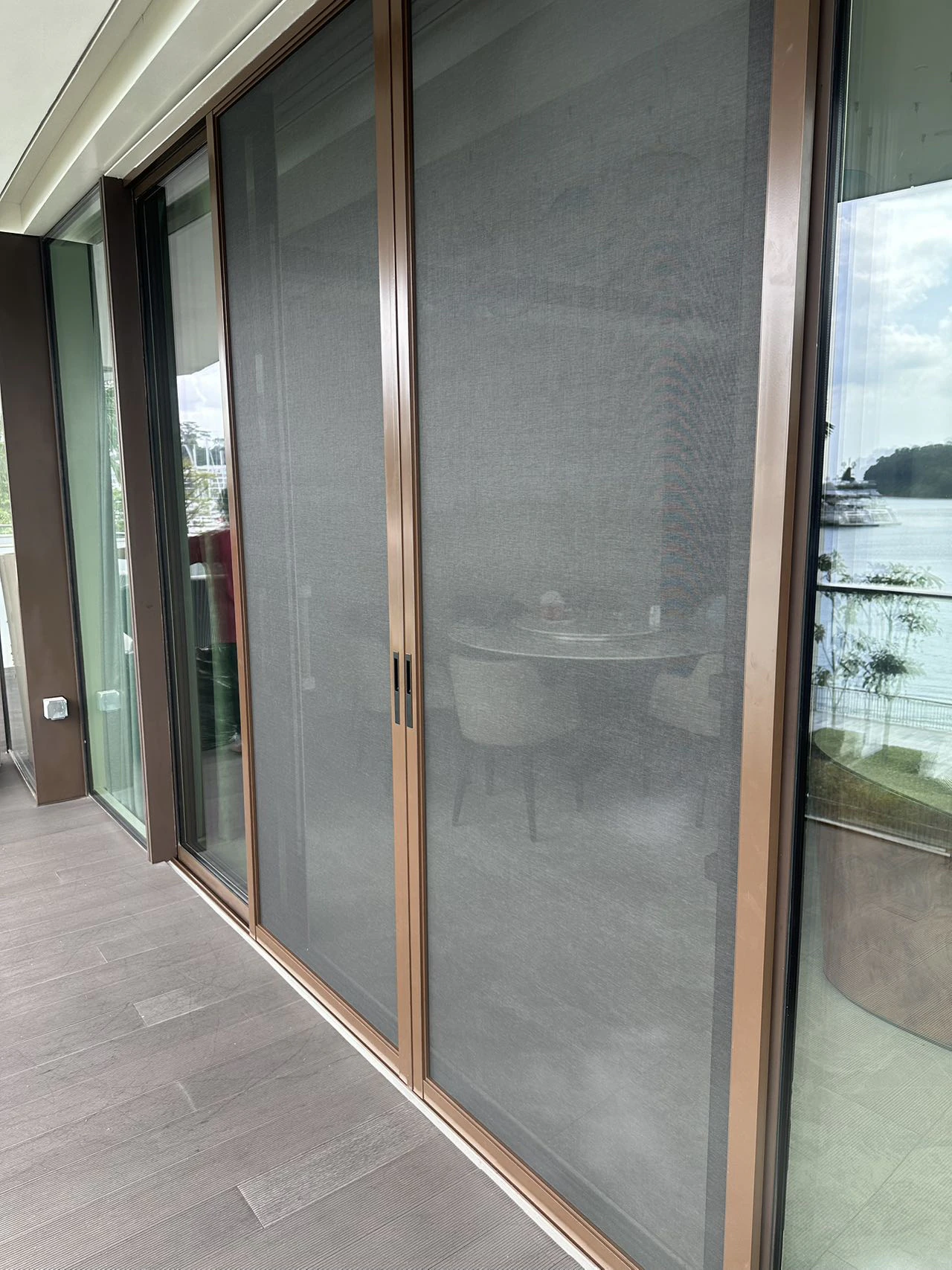 Sliding mosquito mesh panels across a wide balcony door